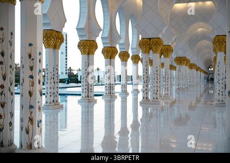 Photographie d'intérieur de la mosquée sheikh zayed à abu dhabi eau, Grande mosquée au coucher du soleil, heure d'or, rangée de piliers à l'intérieur de la mosquée Banque D'Images