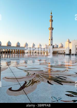 Lumière du matin dans la grande mosquée à abu dhabi, sol incrusté de marbre, dôme blanc, minarets hauts et élégants, intérieur complexe de mosquée avec architecte islamique Banque D'Images