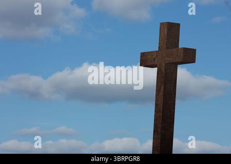 Illustration de conception plate montrant une croix en bois debout contre un ciel bleu pâle parsemé de nuages Banque D'Images