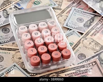 Calculatrice rose reposant sur des billets de cent dollars des États-Unis, calculant le revenu, la planification financière et le concept comptable Banque D'Images