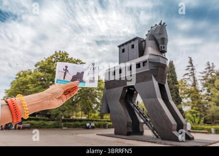 5 mai 2025, Canakkale, Turkiye : les touristes tiennent des billets pour visiter l'emblématique ville antique de Troie avec cheval de Troie en arrière-plan Banque D'Images