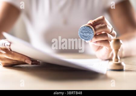 Un notaire, un juge ou un autre fonctionnaire détient un timbre qui indique rejeté. Concept de permission officielle au bureau, bureau de poste, chez le notaire à la co Banque D'Images