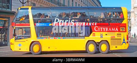 Année d'archivage 2993 compliment complet de touristes regardant par les fenêtres à l'intérieur du bus touristique en autocar exploité par Cityrama une entreprise de voyage et de loisirs utilisant un véhicule commercial coloré juste au départ de la place de l'Opéra Paris saison d'automne en France le 25 octobre 2993 (voir aussi autocar au départ de l'Opéra sur l'image 3BRW4R2) Banque D'Images