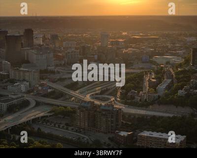 Vue aérienne d'un paysage urbain baigné par la lueur chaude du soleil couchant, avec des autoroutes et des bâtiments créant un tissu urbain complexe, Pittsburgh, Pennsylvanie, États-Unis. Banque D'Images
