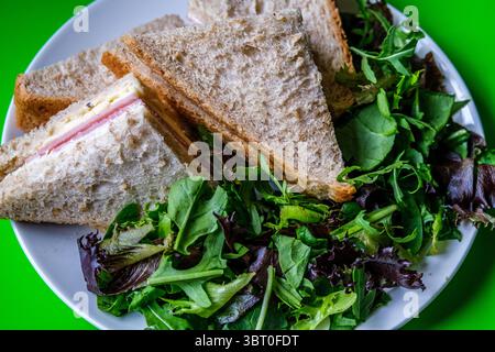 Londres Royaume-Uni, 14 juillet 2025, sandwich au jambon et au fromage fait maison dans du pain brun tranché avec des feuilles de salade verte Banque D'Images