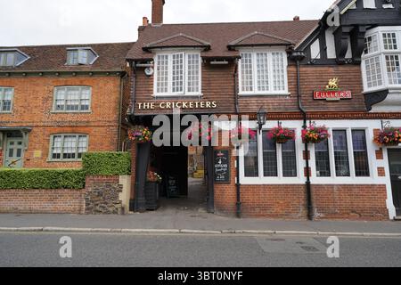 Bâtiment traditionnel de pub anglais avec façade en brique et paniers de fleurs suspendus. Dorking, Angleterre Banque D'Images