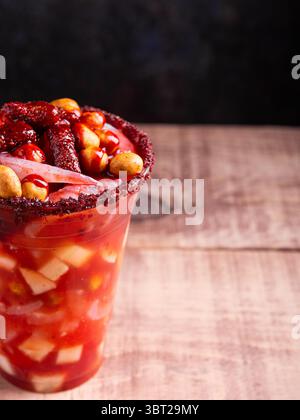 Petit verre fou, un mélange d'ingrédients sucrés, salés et épicés. Snack typique du Mexique. Banque D'Images