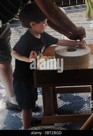 Le garçon essaie de travailler sur de vieux équipements, le moulin à Grist de Plimoth, Plymouth, Massachusetts, Nouvelle-Angleterre, États-Unis Banque D'Images