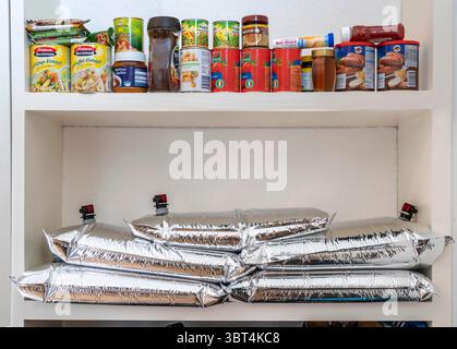 Préparation aux situations d'urgence, entreposage des aliments dans un ménage privé, étagère, garde-manger, avec des aliments de longue durée, sac d'eau de 10 litres, pour le stockage de l'eau potable à ho Banque D'Images