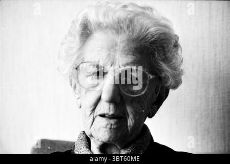 MRS Valk de vos a 100 ans à Haarlem Haarlem pays-Bas, Whizgle News, Dutch Desk, pays-Bas, 1950 - 2000 sur 03-12-1997. L'image inclut ces rubriques. Dans un gros plan, une femme âgée remplit le cadre, son visage transmettant une richesse d'expériences de vie et de sagesse. Elle a des cheveux doux et blancs soigneusement coiffés, encadrant son visage doucement. De grandes lunettes rondes se tiennent bien en évidence sur son nez, accentuant ses yeux expressifs, qui tiennent un regard serein et réfléchi. L'éclairage est doux et diffus, créant une ambiance douce qui met en valeur les contours de son visage et le délicat Banque D'Images