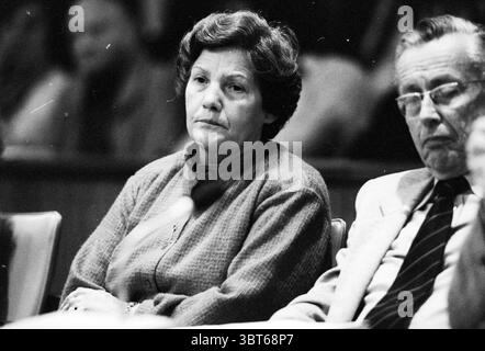 Réunion du conseil Fish Eye IJm + conseillers IJm Municipal Council IJmuiden IJmuiden pays-Bas, Whizgle News, Dutch Desk, pays-Bas, 1950 - 2000 on 17-11-1980. Ces rubriques sont illustrées dans l'image. Dans la scène, une femme s’assoit avec une expression solennelle, son visage marqué par un profond sens de la contemplation. Elle a des cheveux ondulés de longueur moyenne, coiffés dans des boucles douces, et porte un vêtement texturé et boutonné qui semble être dans un ton doux, peut-être gris ou beige. Son expression transmet le sérieux, faisant allusion au poids des circonstances qui l'entourent. À côté d'elle, un homme est assis avec un réservé Banque D'Images