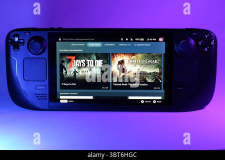 Gros plan de la console de jeu Steam Deck illuminée par un éclairage ambiant coloré Banque D'Images