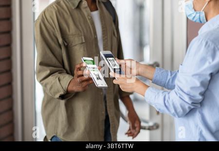 Contrôle Covid-19. Code QR du visiteur noir à l'entrée de la santé des travailleurs à la numérisation Banque D'Images