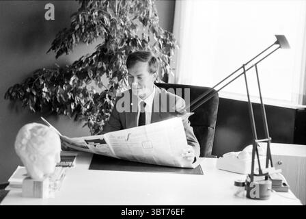 Portrait de Mr. A.P. Lugt Directeur des ventes de VNU Amsterdam VNU Association des éditeurs hollandais Amsterdam pays-Bas, Whizgle News, Dutch Desk, pays-Bas, 1950 - 2000 le 15-07-1983. Voici les rubriques de l'image. La scène se déroule dans un bureau élégant et moderne caractérisé par des lignes épurées et une esthétique minimaliste. Un homme est assis à un grand bureau blanc avec un éclat subtil, occupé à lire un journal. Il est habillé d'un costume à carreaux pointu qui contraste bien avec les tons monochromes du bureau, exsudant le professionnalisme. Derrière lui, une grande plante verte ajoute une touche de vie à t Banque D'Images