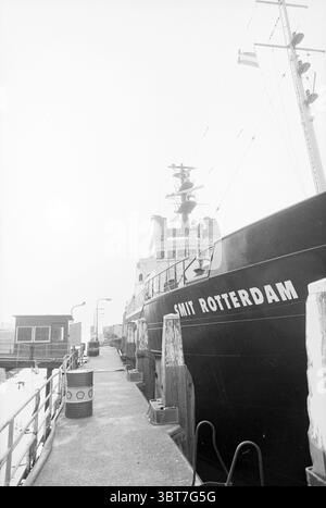 Remorqueur de mer Smit Rotterdam de Smit internationale de Rotterdam qui a été amarré à la jetée Wijsmuller IJmuiden IJmuiden pays-Bas, Whizgle News, Dutch Desk, pays-Bas, 1950 - 2000 le 09-04-1992. L'image contient ces rubriques. La scène montre un port animé avec un grand navire amarré bien en vue sur la droite. Le navire, peint dans des teintes sombres, affiche le nom « Smit Rotterdam » en caractères gras le long de son flanc. Sa structure comporte différents niveaux, avec des ponts qui sont ornés d'équipements et divers appareils d'expédition. À gauche, il y a des bâtiments plus petits qui contribuent à Banque D'Images
