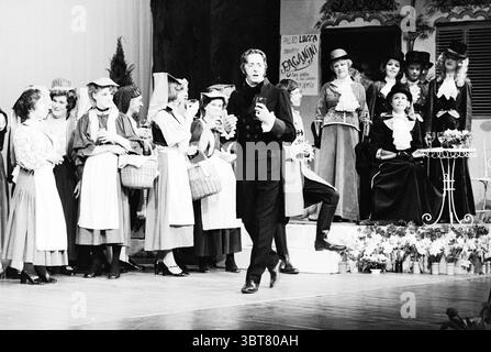Opérette Paganini Opera opérette, Whizgle News, Dutch Desk, pays-Bas, 1950 - 2000 le 03-04-1977. Ce sont les éléments de l'image. La scène capture une performance théâtrale animée, sur un fond stylisé qui suggère un charme pittoresque et ancien. L'éclairage est doux et chaleureux, projetant de douces ombres qui renforcent l'ambiance de nostalgie. Un groupe d'interprètes, principalement des femmes, occupe le premier plan. Ils sont habillés de costumes élaborés, avec de longues jupes et chemisiers, avec quelques chapeaux distinctifs sportifs ornés de rubans. Les couleurs variées des vêtements – les pastels se combinent Banque D'Images