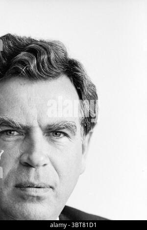 Portrait de Mr. Minting AWV, Whizgle News, Dutch Desk, pays-Bas, 1950 - 2000 on 11-08-1992. Ces rubriques apparaissent dans l'image. La scène capture la moitié supérieure du visage d’un homme, soulignant son expression et ses traits sur un fond clair et neutre qui suggère un studio ou un cadre intérieur. L'homme a des cheveux foncés et ondulés qui semblent épais, stylisés en arrière avec un volume naturel. Ses sourcils sont proéminents et légèrement sillonnés, véhiculant une humeur sérieuse ou contemplative. L’éclairage est doux, soulignant les contours de ses pommettes et les lignes subtiles de l’âge autour de ses yeux et de sa bouche Banque D'Images