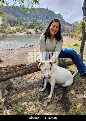 Une femme adulte latina passe du temps à l'extérieur avec son chien de soutien émotionnel comme thérapie pour le stress et l'anxiété Banque D'Images