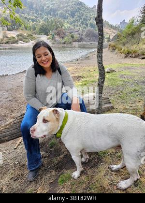 Une femme adulte latina passe du temps à l'extérieur avec son chien de soutien émotionnel comme thérapie pour le stress et l'anxiété Banque D'Images