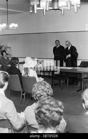 Mariage Beverwijk mariage, Whizgle News, Dutch Desk, pays-Bas, 1950 - 2000 on 20-12-1971. Ces rubriques sont illustrées dans l'image. La scène se déroule dans un cadre intérieur formel, caractérisé par des tons de terre discrets et une atmosphère professionnelle. Un groupe d'individus est assis dans des rangées ordonnées, leur attention concentrée vers une table centrale où une occasion formelle semble avoir lieu. La chambre est habillée dans un style moderne du milieu du siècle, avec une série de luminaires élégants qui diffusent une douce lueur à travers l'espace. L'éclairage projette des ombres douces, contribuant à un m réfléchissant Banque D'Images
