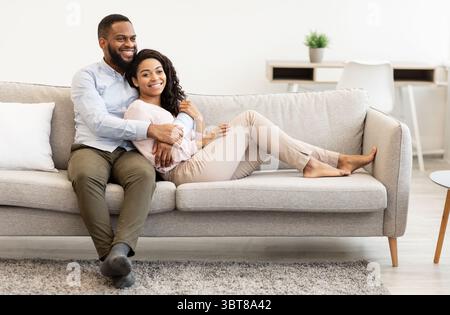Couple afro-américain qui passe un week-end ensemble allongé sur un canapé Banque D'Images
