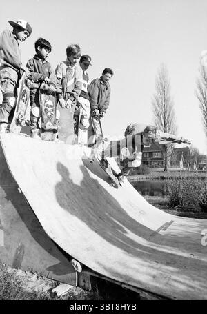 Skateboard track Sweelinkplein Heemstede Skating Heemstede Sweelinckplein pays-Bas, Whizgle News, Dutch Desk, pays-Bas, 1950 - 2000 le 09-02-1989. Ces rubriques sont illustrées dans l'image. Dans un cadre extérieur animé, une scène vibrante se déroule sur une rampe de skateboard. Un groupe de jeunes skateurs se tient au bord, leurs expressions rayonnant d'excitation et d'anticipation. Ils portent des vêtements décontractés typiques de la culture du skate, avec un mélange de motifs et de couleurs Unies, mettant en valeur des styles allant du short baggy aux t-shirts surdimensionnés. Certains sont ornés de capuchons positionnés à différents angles Banque D'Images
