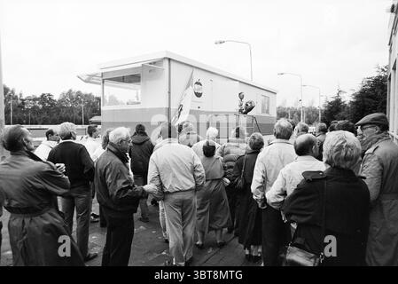 Ouverture de la cage du chronométreur de patinoire Haarlem ouverture ouverture mise en service hockey sur glace de patinoire Haarlem pays-Bas, Whizgle News, Dutch Desk, pays-Bas, 1950 - 2000 le 29-10-1989. Ce sont les éléments de l'image. Dans la scène, un groupe diversifié d'individus se tient rassemblés en demi-cercle, le dos face au spectateur. La foule est composée principalement de personnes âgées, portant une variété de vêtements d'extérieur typiques du temps plus frais, tels que des vestes et des manteaux dans des tons de gris, brun et des couleurs sourdes. Beaucoup de gens portent des chapeaux ou des foulards, indiquant le froid dans l'air. Au cent Banque D'Images