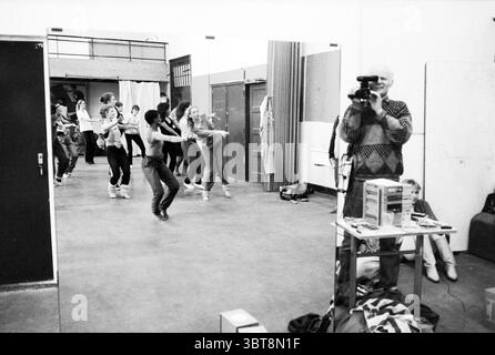Week-end de danse dans l'Egelantier danser Haarlem Gasthuisvest pays-Bas, Whizgle News, Dutch Desk, pays-Bas, 1950 - 2000 le 22-02-1987. L'image montre ces rubriques. La scène capture une répétition de danse animée qui se déroule dans une salle spacieuse et bien éclairée avec un sol poli. Des miroirs bordent un mur, reflétant les mouvements énergiques d'un groupe de danseurs engagés dans leur routine. Les danseurs, un groupe diversifié principalement vêtus de vêtements sportifs décontractés, présentent une gamme de styles et d'expressions, mettant en valeur à la fois la concentration et la joie lorsqu'ils synchronisent leurs pas. Certains sont à mi-mouvement, les bras sortis Banque D'Images