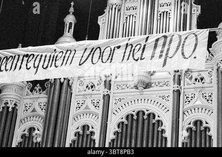 Concert NPO en lien avec Keep ITS Own Name North Holland Philharmonic Orchestra, Whizgle News, Dutch Desk, pays-Bas, 1950 - 2000 on 14-11-1982. L'image inclut ces rubriques. Dans la scène, une structure architecturale ornée domine l'arrière-plan, mettant en valeur des conceptions complexes et des détails typiques des grands intérieurs. Le cadre semble être dans un hall ou un auditorium spacieux, caractérisé par de hauts plafonds et un mélange d'éléments classiques et ornés. La structure est composée de colonnes élaborées et de motifs décoratifs, avec un affichage proéminent de tuyaux suggérant la présence Banque D'Images