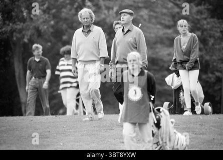 Pro-Am Spaarnwoude Spaarnwoude, Whizgle News, Dutch Desk, pays-Bas, 1950 - 2000 le 15-08-1992. Ces rubriques apparaissent dans l'image. La scène capture un moment animé sur un terrain de golf, où plusieurs individus se fraient un chemin à travers un paysage verdoyant en pente douce. Le fond est luxuriant, rempli d'arbres qui créent un cadre serein et naturel. Au premier plan, un groupe de golfeurs marche étroitement ensemble, engagés dans la conversation. Les deux personnages principaux sont des hommes vêtus d'une tenue de golf légère et décontractée. Un homme porte un pull léger et des pantalons sport, tandis que l'autre a un plus classique Banque D'Images