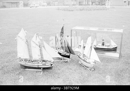 Modèles réduits de bateaux de pêche avec des voiles exposées sur une pelouse, Whizgle News, Dutch Desk, pays-Bas, 1950 - 2000 en 1967. Ces rubriques sont illustrées dans l'image. La scène met en valeur une zone herbeuse, principalement un champ vert vibrant qui est légèrement inégal, laissant entendre la présence d'un terrain vallonné. Dispersés dans cet espace sont plusieurs modèles de voiliers, chacun soigneusement conçu avec des détails complexes. Ces navires varient en taille, avec le plus grand affichant un éventail impressionnant de voiles gonflantes, certaines blanches et d'autres dans des tons de noir et bleu foncé, contrastant efficacement avec le t plus clair Banque D'Images
