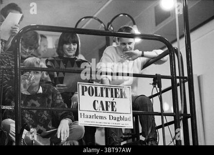 Café politique Haarlems Dagblad, Whizgle News, Dutch Desk, pays-Bas, 1950 - 2000 le 26-01-1982. Voici les rubriques de l'image. La scène se déroule dans un environnement de café animé, caractérisé par une atmosphère distincte et détendue. Dans une zone surélevée, plusieurs personnes sont rassemblées, créant un sentiment de communauté et d’engagement. La composition comprend quatre personnes, chacune affichant des expressions et des activités variées. Un individu, portant un pull sombre orné de motifs colorés, semble boire dans un verre, ajoutant une sensation décontractée au moment. A proximité, une femme avec courte, droite Banque D'Images