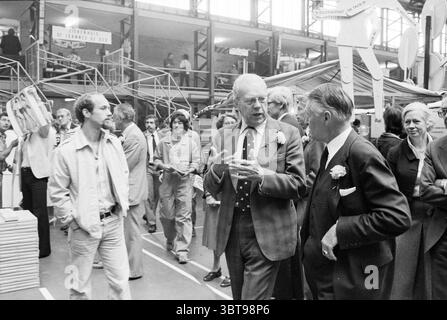 Ouverture du marché de l'emploi du ministre Albeda et des stands Kennemersporthal politique du marché politique des gens Haarlem pays-Bas, Whizgle News, Dutch Desk, pays-Bas, 1950 - 2000 le 23-08-1979. Ce sont les éléments de l'image. La scène capture un environnement intérieur animé, probablement un événement public ou une exposition. Un groupe diversifié de personnes remplit l'espace, engagées dans diverses conversations et activités. Au premier plan, deux hommes sont en vedette ; l'un porte une cravate à motifs et un costume sombre, faisant des gestes animés avec ses mains, tandis que l'autre, vêtu d'un costume de couleur plus claire, écoute Banque D'Images