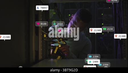 Accroupissement homme en chemise légère organisant les câbles dans le rack de serveur, affichant les icônes sociales, espace de copie Banque D'Images