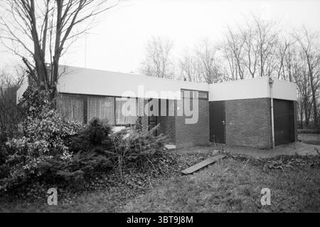 Extérieur résidence officielle Heimanshof Hoofddorp maisons extérieures et construction de maisons Hoofddorp Wieger Bruinlaan pays-Bas, Whizgle News, Dutch Desk, pays-Bas, 1950 - 2000 on 10-01-1990. Ces rubriques sont illustrées dans l'image. La scène représente une maison moderne et minimaliste caractérisée par un toit plat et des lignes épurées. La structure est construite à partir d'une combinaison de briques et de panneaux blancs lisses, créant un contraste frappant entre les deux matériaux. D'un côté, de grandes fenêtres permettent d'apercevoir l'intérieur, où les rideaux transparents diffusent la lumière, laissant entendre une atmosphère chaleureuse insi Banque D'Images