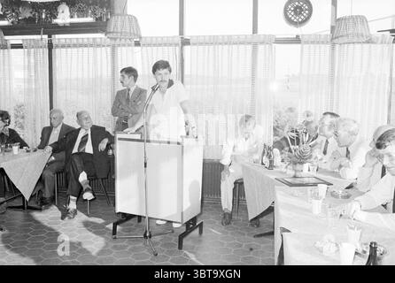 Réception VV Stormvogels réceptions Football V.S.V. Velsen Stormvogels, Whizgle News, Dutch Desk, pays-Bas, 1950 - 2000 on 02-06-1979. Voici les rubriques de l'image. Dans ce cadre intérieur animé, un rassemblement a lieu dans un lieu élégamment décoré. La salle dispose de grandes fenêtres ornées de rideaux transparents de couleur claire qui permettent à une lumière douce et naturelle de filtrer, créant une atmosphère chaleureuse et accueillante. À l’avant-garde, un orateur se tient en toute confiance sur un podium, engageant le public avec des gestes animés. Il est habillé dans une tenue simple, mais élégante qui contraste avec W. Banque D'Images