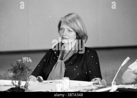 Portraits de membres du conseil H'stede pour les noms voir couverture Conseil municipal de Heemstede Heemstede pays-Bas, Whizgle News, Dutch Desk, pays-Bas, 1950 - 2000 le 31-05-1979. L'image contient ces rubriques. Dans un cadre professionnel, une femme est assise à une table ornée de divers papiers et documents. Elle a une expression engagée, suggérant qu'elle est impliquée dans une discussion. Sa tenue comprend une blouse sombre avec des embellissements subtils, créant un look élégant mais discret. Autour de son cou, elle porte un foulard de couleur claire qui ajoute un léger contraste à sa tenue. L'atmosphe Banque D'Images