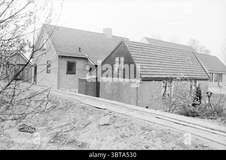 Maison ancienne et nouvelle maison Hoofddorp Kruisweg Hoofddorp maisons et construction de maisons Hoofddorp Kruisweg pays-Bas, Whizgle News, Dutch Desk, pays-Bas, 1950 - 2000 le 04-05-1984. Ces rubriques apparaissent dans l'image. La scène capture un cadre serein et rural dominé par un mélange de maisons traditionnelles aux styles architecturaux distincts. Au premier plan, un chemin de terre mène le long du bord d'un petit remblai, suggérant une route ou un sentier non pavé qui invite à l'exploration. D'un côté, une structure modeste présente principalement un revêtement en bois sombre, placé contre des tons plus clairs de buil adjacent Banque D'Images