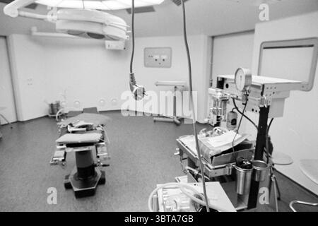 Intérieur de la salle d'opération de l'Hôpital Naval Overveen dans sa dernière semaine en tant qu'hôpital militaire. La fermeture est le 01-06-1990. Bloemendaalseweg Overveen. Overveen Bloemendaalseweg, Whizgle News, Dutch Desk, pays-Bas, 1950 - 2000 on 23-05-1990. Voici les rubriques de l'image. La scène présente un cadre médical, en particulier une salle d'opération. L'accent est mis sur une table chirurgicale centrale, qui semble stérile et organisée, avec divers instruments soigneusement disposés à proximité. La table a une surface propre et rembourrée, ce qui indique qu'elle est prête à l'emploi. Autour de la table, la salle dispose d'un au Banque D'Images