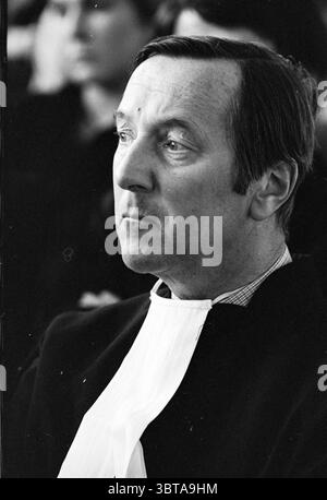 Gavel juges Haarlem et installation de 4 juges Tribunal de district Haarlem pays-Bas, Whizgle News, Dutch Desk, pays-Bas, 1950 - 2000 le 18-04-1979. L'image inclut ces rubriques. La scène capture un moment solennel centré sur un homme avec une expression composée. Il a des cheveux foncés soigneusement coiffés, et son visage montre des signes de réflexion, avec des sourcils légèrement sillonnés et un comportement sérieux. Il est habillé en tenue formelle, caractérisé par un manteau foncé et un col blanc, suggérant un contexte autoritaire ou professionnel. L'arrière-plan est légèrement flou, faisant allusion à un rassemblement de personnes, Banque D'Images