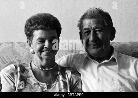 Famille Koehorst mariée depuis 50 ans, Whizgle News, Dutch Desk, pays-Bas, 1950 - 2000 le 15-08-1994. L'image montre ces rubriques. La scène met en scène un couple âgé assis étroitement ensemble sur un canapé à motifs. La femme a les cheveux courts et bouclés et porte une chemise florale qui éclate de couleurs douces, qui contraste chaudement avec sa peau claire. Elle sourit avec éclat, révélant une série de douces rides qui mettent en valeur son expression joyeuse. Ses accessoires comprennent une chaîne de perles autour de son cou, ajoutant une touche d'élégance. À côté d'elle, l'homme a des cheveux soigneusement peignés qui ont turne Banque D'Images