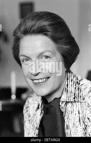 MRS Einthoven old Milva Military, Whizgle News, Dutch Desk, pays-Bas, 1950 - 2000 le 27-09-1978. Voici les rubriques de l'image. La scène met en scène une femme avec une expression chaleureuse, caractérisée par son sourire éclatant et ses yeux vifs et engageants. Elle a une coiffure classique, soigneusement coiffée avec des vagues douces, donnant un sentiment d'élégance. Sa tenue se compose d'une blouse à motifs avec des rayures subtiles et une écharpe sombre drapée autour de son cou, ajoutant une touche de sophistication. L'arrière-plan est doux et indistinct, faisant allusion à un cadre intérieur. L'éclairage est doux, créant une ambiance chaleureuse que salut Banque D'Images