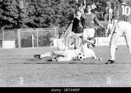 Telstar - FC Groningen Velsen, Whizgle News, Dutch Desk, pays-Bas, 1950 - 2000 le 24-06-1979. Ces rubriques sont illustrées dans l'image. La scène se déroule sur un terrain de football herbeux, vibrant et luxuriant de soins récents. Un groupe de joueurs est engagé dans un moment dynamique du jeu, leurs formes athlétiques capturées en action. Au premier plan, deux joueurs sont en évidence. L’une, vêtue d’un uniforme blanc, est étalée sur le sol, venant d’être abordée, avec détermination évidente dans leur expression. Le deuxième joueur, portant un maillot rouge vif avec le numéro 8, est en mi-mouvement, Havin Banque D'Images