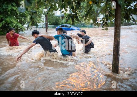 Plainfield, New Jersey, États-Unis. 14 juillet 2025. Les gens essaient de traverser les eaux de crue de Richmond Street à Plainfield, New Jersey. Les automobilistes et les résidents ont été laissés bloqués dans leurs voitures, dans le lycée local et des rapports faisant état de maisons inondées. Plus tôt en juillet, Plainfield a perdu la vie à cause d'une tempête violente qui contenait de la grêle et des vents violents détruisant des lignes électriques et endommageant des maisons à Plainfield ainsi que dans d'autres villes du centre du Jersey. Crédit : ZUMA Press, Inc/Alamy Live News Banque D'Images