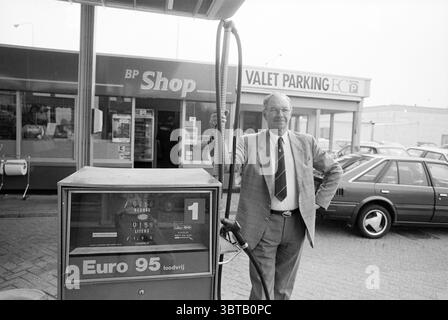 Mr. by. District BP Schiphol Schiphol Schiphol, Whizgle News, Dutch Desk, pays-Bas, 1950 - 2000 le 26-04-1990. L'image contient ces rubriques. La scène montre un homme debout à côté d'une pompe à essence vintage, exsudant un sentiment de nostalgie. Il porte un costume de couleur claire avec une cravate à motifs, sa posture confiante comme il se penche contre la pompe. La pompe à essence est bien en vue, affichant des cadrans et un tuyau, transmettant une ambiance rétro avec ses tonalités silencieuses. En arrière-plan, un bâtiment au toit arrondi affiche de grandes fenêtres, permettant un aperçu de l'intérieur. L'établissement a un propre et org Banque D'Images