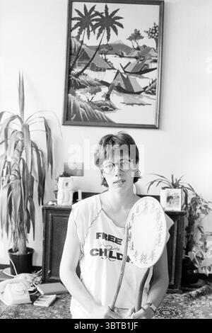 Irene Wijne écrivain Haarlem écrivant les gens Haarlem pays-Bas, Whizgle News, Dutch Desk, pays-Bas, 1950 - 2000 le 28-07-1988. L'image montre ces rubriques. Dans un cadre intérieur très éclairé, un jeune adulte se tient en toute confiance au centre de la scène. Ils sont habillés dans un haut blanc décontracté et sans manches qui transmet un sentiment de simplicité et de franchise. Leurs cheveux courts encadrent leur visage, qui affiche une expression réfléchie derrière une paire de lunettes. Autour de cette figure, l'arrière-plan est orné d'une grande œuvre d'art encadrée représentant un paysage serein, avec un arbre stylisé Banque D'Images