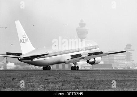 Boeing 767 Schiphol, Whizgle News, Dutch Desk, pays-Bas, 1950 - 2000 sur 28-07-1995. L'image montre ces rubriques. Dans cette scène, un gros avion commercial, identifiable par sa carrosserie épurée et son design distinctif, est positionné sur une piste. L'avion, orné de la marque KLM, présente un extérieur à prédominance blanche avec des accents bleus, véhiculant un sentiment de professionnalisme et de voyage en avion. Les ailes sont légèrement inclinées vers le haut, suggérant une posture prête pour le décollage ou l'atterrissage. En arrière-plan, une tour de contrôle de la circulation aérienne se dresse contre un horizon brumeux, sa silhouette marquée b Banque D'Images