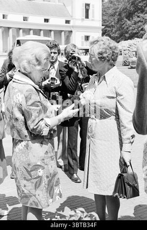 Rendez visite à des personnes âgées de Haarlem à la reine Juliana au Palais Soestdijk Soestdijk, Whizgle News, Dutch Desk, pays-Bas, 1950 - 2000 le 05-06-1974. Ces rubriques sont illustrées dans l'image. Dans un cadre extérieur caractérisé par une ambiance formelle, deux femmes s’engagent dans un moment d’échange. Une femme, portant une robe à motifs ornée de motifs floraux éclatants, se tient à gauche. Sa tenue est complétée par une veste de couleur claire qui met en valeur une élégance sophistiquée. Elle semble étendre un geste d'offre, possiblement présenter un cadeau ou de l'admiration, avec ses mains doucement impliquées Banque D'Images