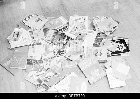 Collage livres de sport livres et libraires, Whizgle News, Dutch Desk, pays-Bas, 1950 - 2000 le 12-11-1973. Ces rubriques sont illustrées dans l'image. La scène présente une gamme vibrante de livres répartis sur un plancher en bois clair. L'assortiment est éclectique, avec une variété de designs et de couleurs de couverture, bien que le traitement monochrome souligne les nuances de gris et de noir. Les livres sont dans un arrangement aléatoire, certains empilés au-dessus d'autres tandis que beaucoup restent ouverts, révélant des pages remplies de diagrammes et d'illustrations liés à divers sports. Les couvertures affichent un mélange d'éléments graphiques, po Banque D'Images