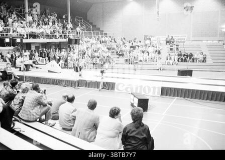 Finales de bowling Beyneshal Bowling Haarlem pays-Bas, Whizgle News, Dutch Desk, pays-Bas, 1950 - 2000 le 21-06-1987. Ces rubriques apparaissent dans l'image. La scène se déroule dans un grand espace intérieur, probablement un gymnase ou un lieu similaire, caractérisé par de hauts plafonds et des sièges en gradins. Les rangées de gradins sont remplies d'un public, principalement des adultes, qui sont engagés et attentifs. L'atmosphère est animée mais concentrée, suggérant que quelque chose d'excitant est en train de se produire ou sur le point de se produire. Au premier plan, un petit groupe de spectateurs occupe le coin inférieur des sièges, leurs expressions un mélange o Banque D'Images
